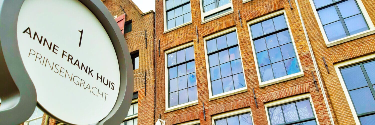 Das Anne Frank Haus in Amsterdam von außen mit einem Schild.