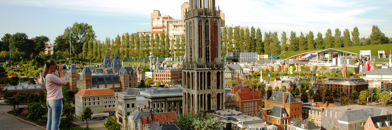 Frau fotografiert Gebäude in Madurodam