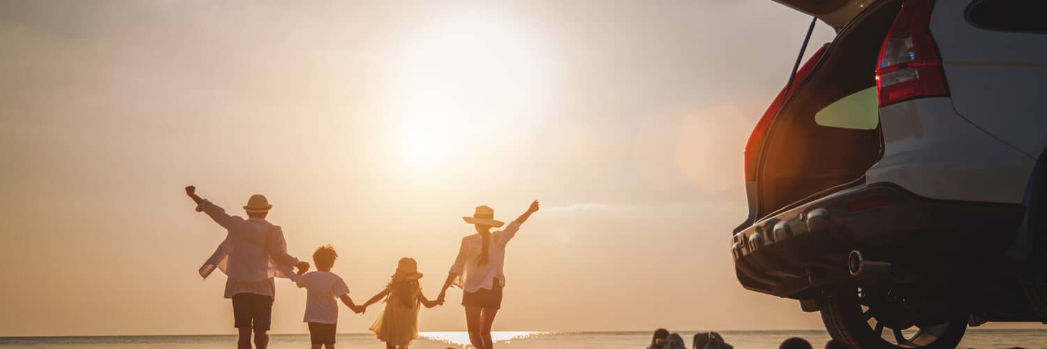 Familie am Strand mit dem Auto